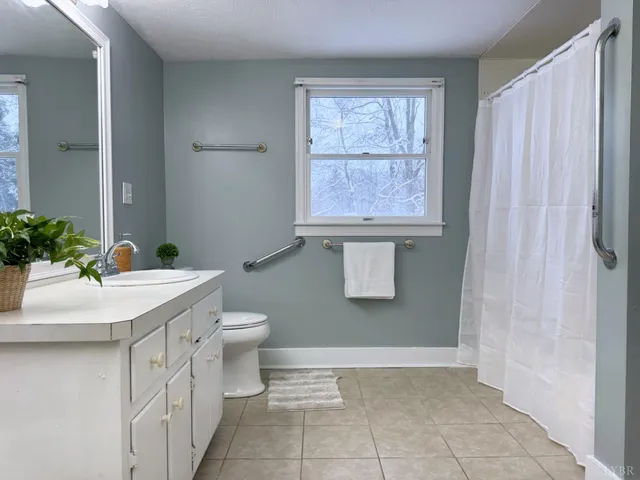 a bathroom with a sink toilet and window