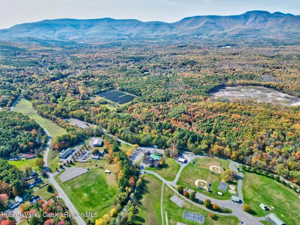 an aerial view of residential house with yard and mountain view in back