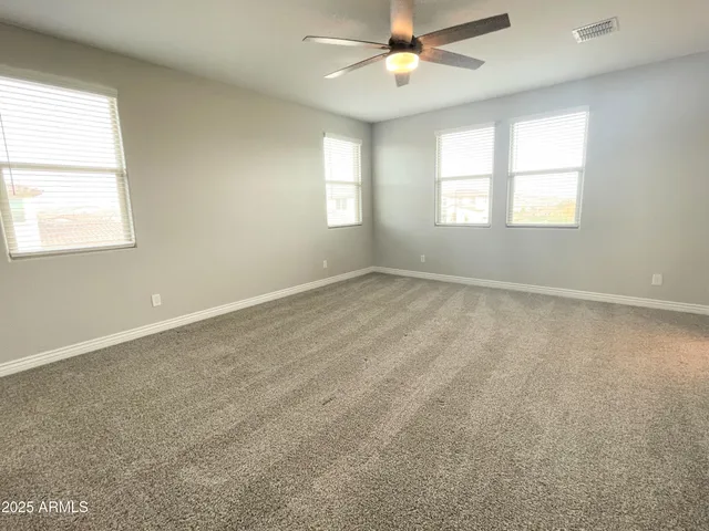 an empty room with a window and a fan