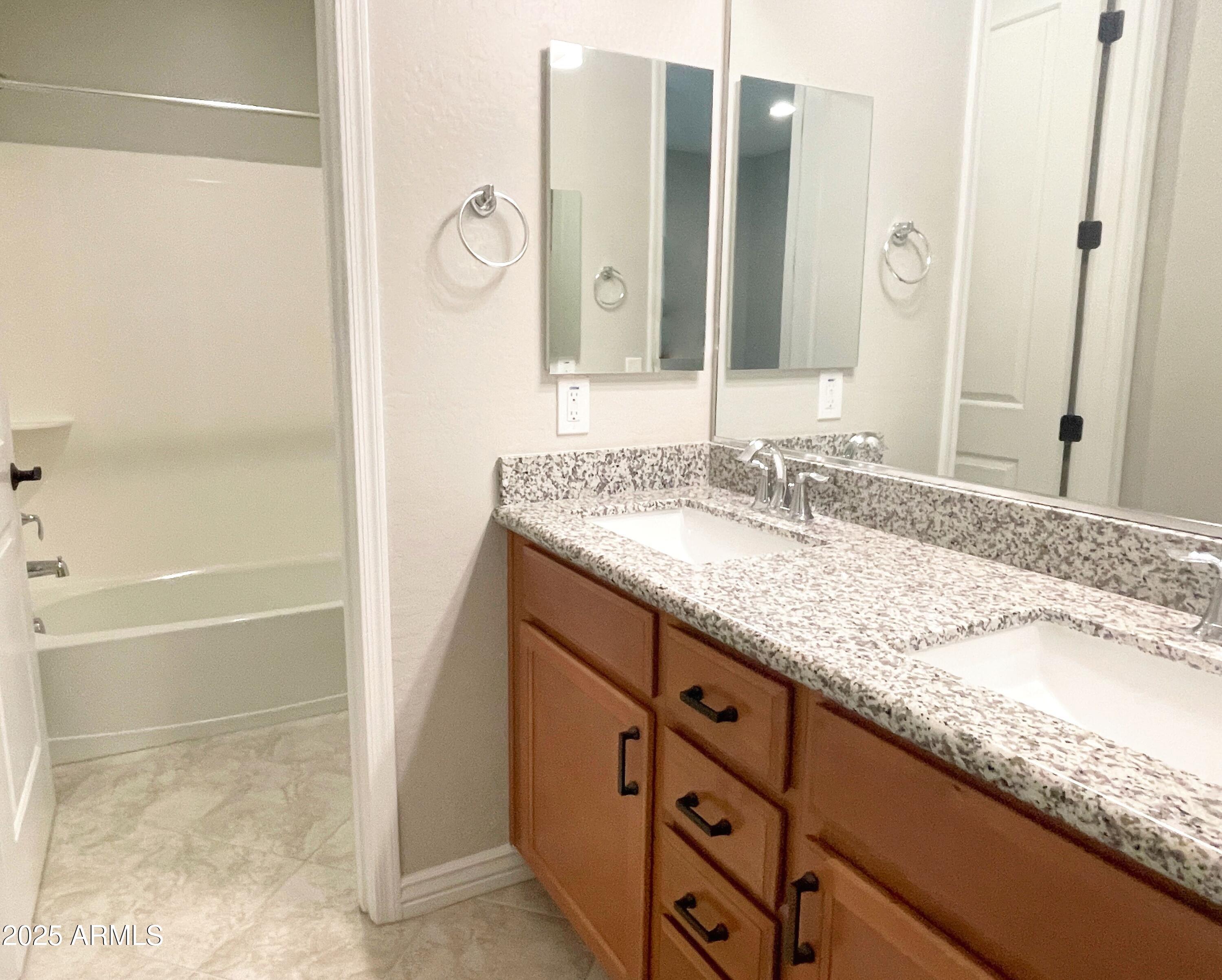 21046 East Mayberry Road Queen Creek, AZ 85142 - Photo 23 of 32 a bathroom with a granite countertop double vanity sink and mirror