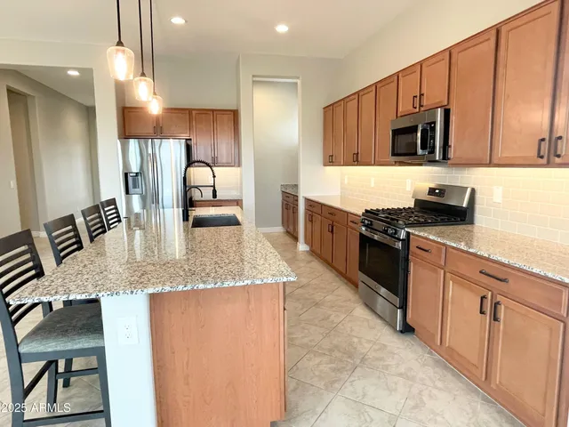 a kitchen with stainless steel appliances granite countertop a sink and stove
