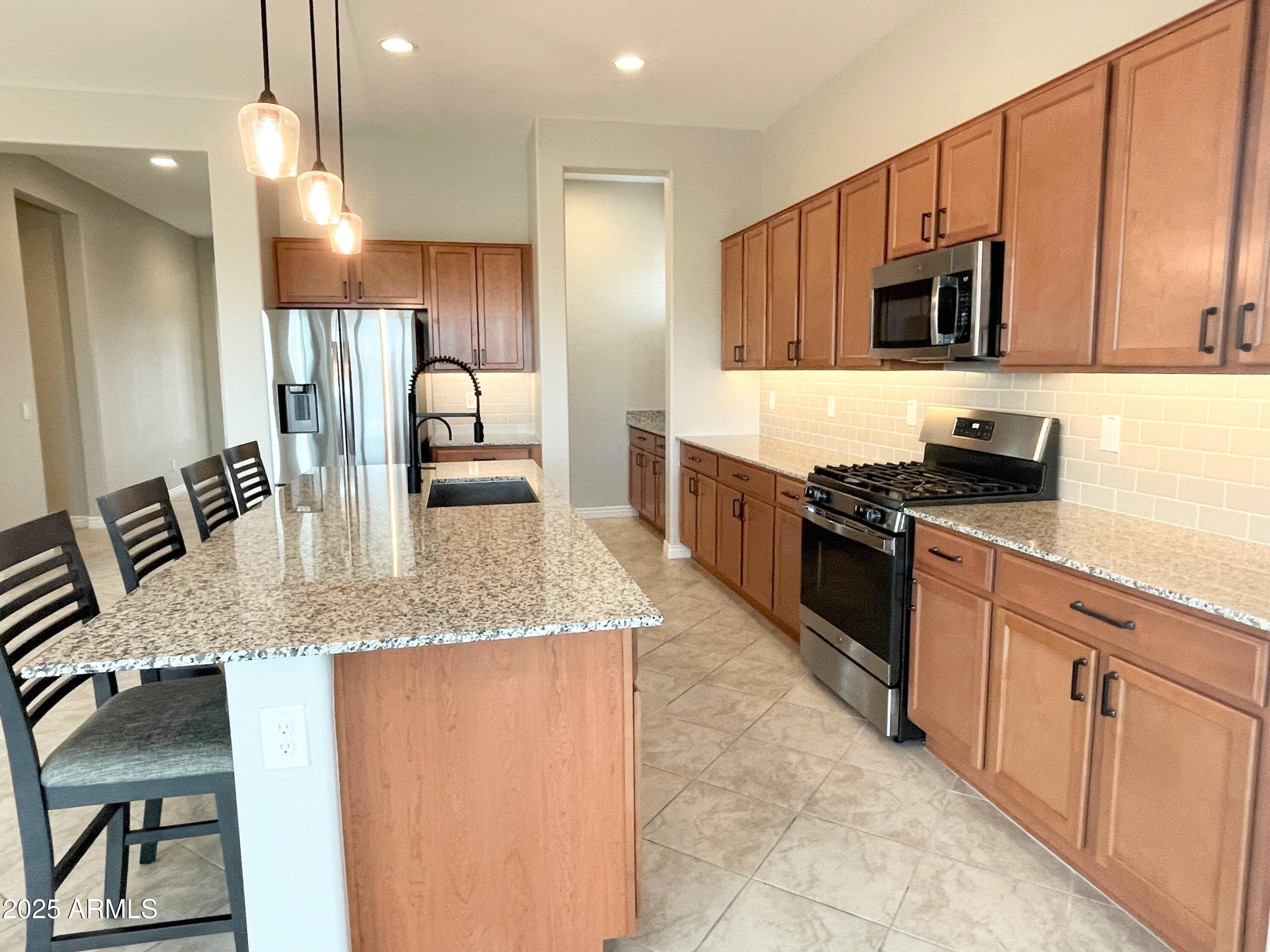 21046 East Mayberry Road Queen Creek, AZ 85142 - Photo 8 of 32 a kitchen with stainless steel appliances granite countertop a sink and stove