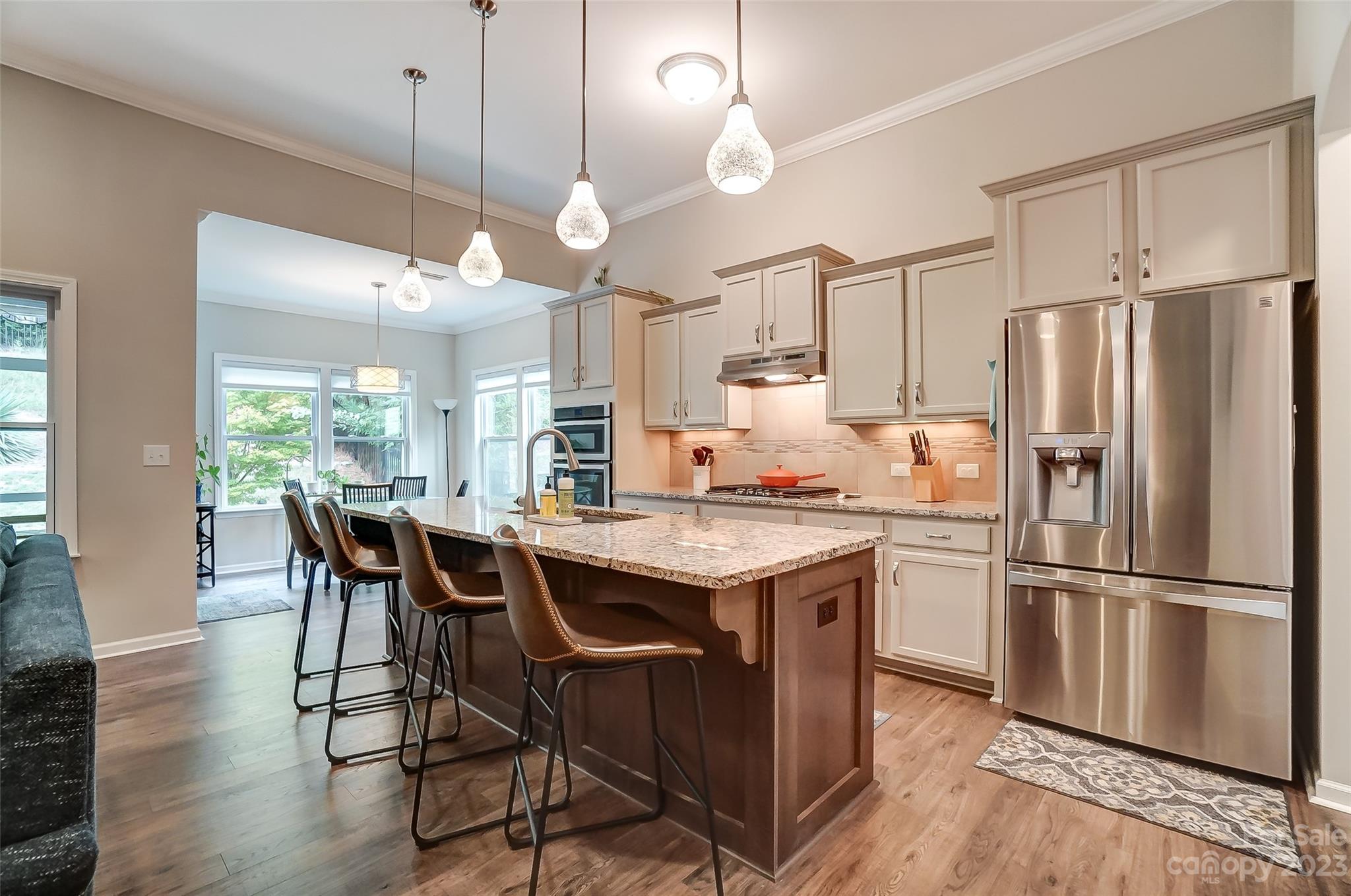 1862 Larkspur Way Tega Cay, SC 29708 - Photo 11 of 37 a kitchen with stainless steel appliances a dining table chairs refrigerator and wooden floor