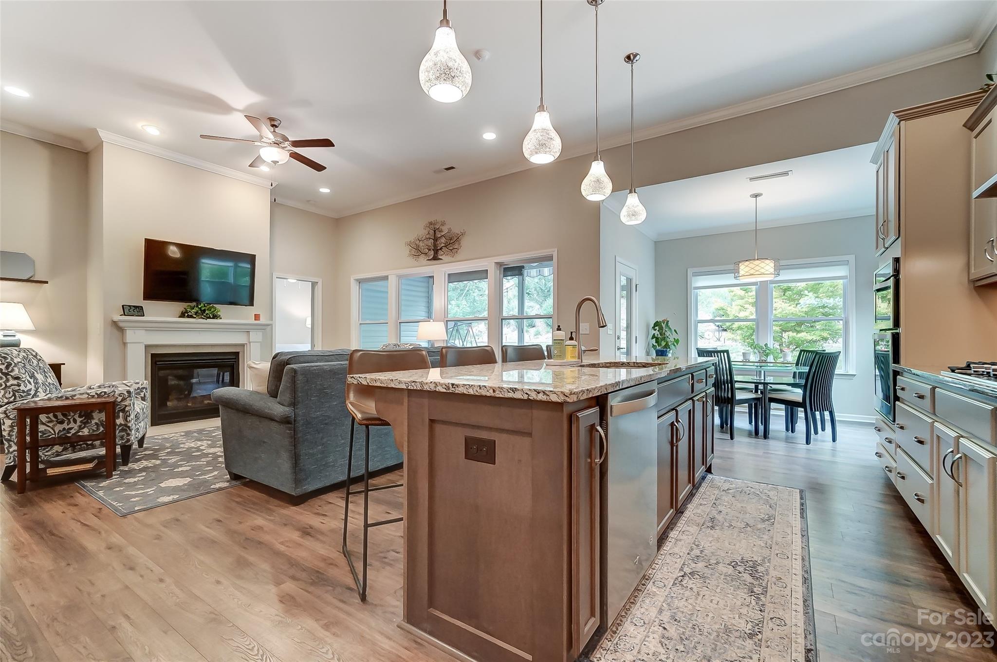 1862 Larkspur Way Tega Cay, SC 29708 - Photo 16 of 37 a kitchen with kitchen island granite countertop a stove top oven a sink a dining table and chairs with wooden floor