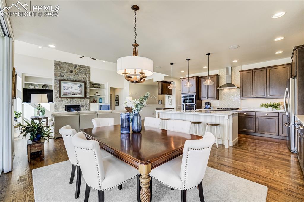 1265 Foothills Farm Way Colorado Springs, CO 80921 - Photo 21 of 50 a kitchen with stainless steel appliances kitchen island granite countertop a table chairs and a refrigerator