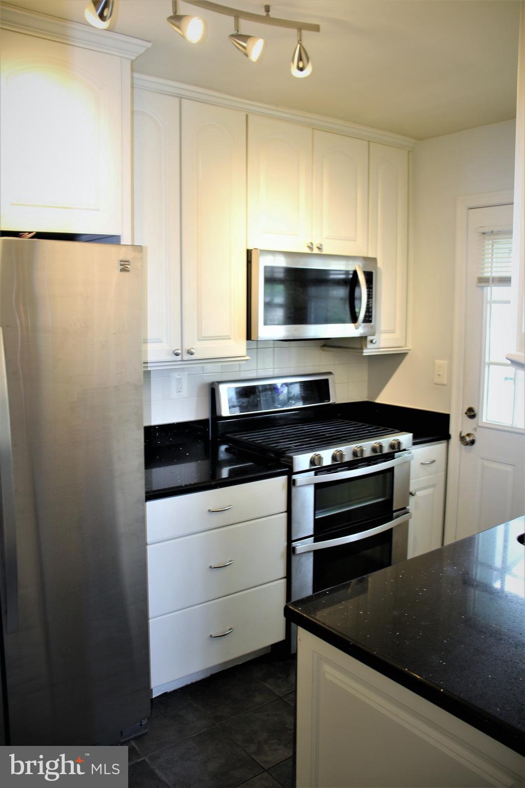 1746 Glen Ridge Road Towson, MD 21286 - Photo 16 of 48 a kitchen with stainless steel appliances a stove a microwave and a sink