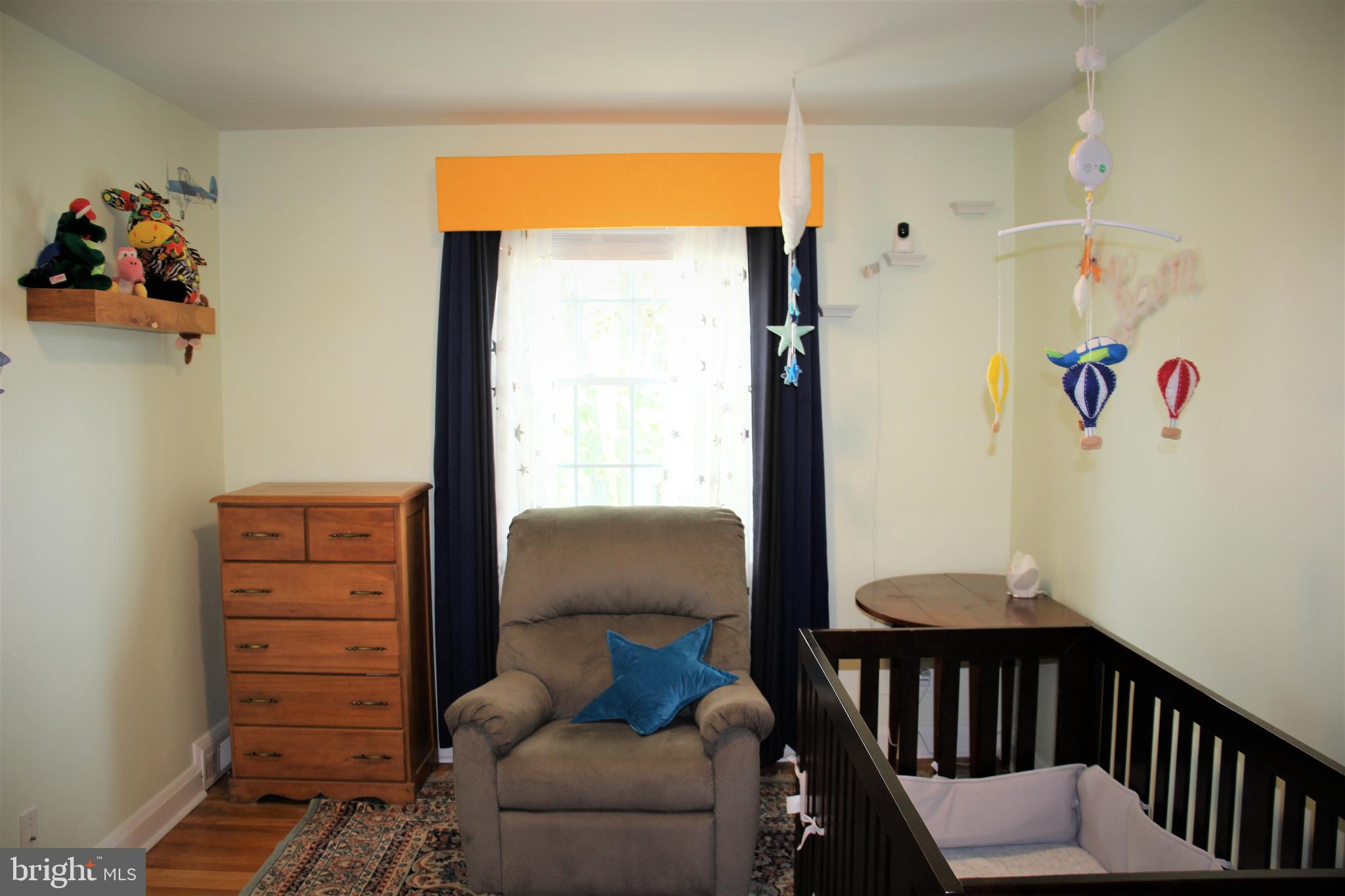 1746 Glen Ridge Road Towson, MD 21286 - Photo 23 of 48 a bedroom with a baby crib a chandelier and a window