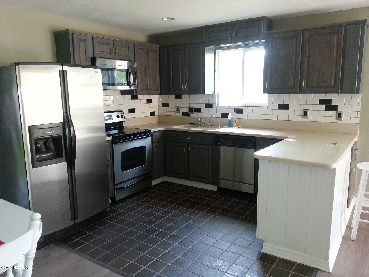 7253 Sandhurst Road South Jacksonville, FL 32277 - Photo 2 of 13 a kitchen with stainless steel appliances a sink a stove a refrigerator and cabinets
