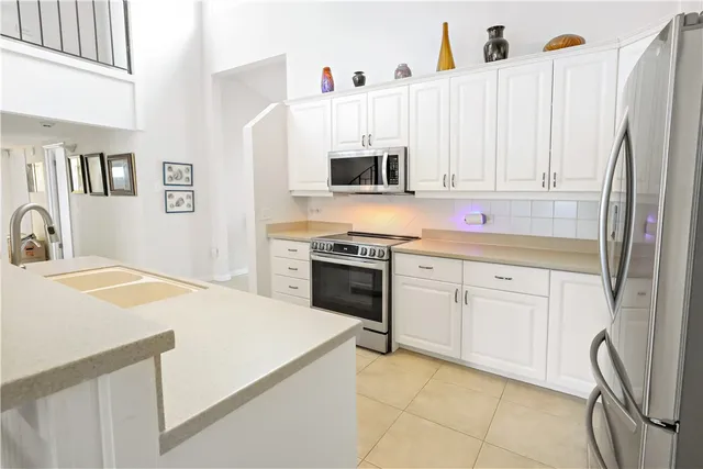 a kitchen with stainless steel appliances white cabinets and a sink