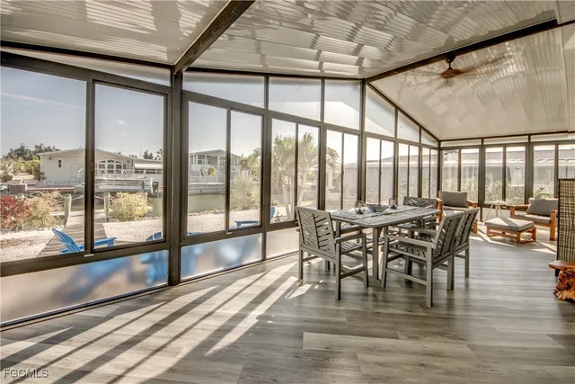 a living room with furniture large window and wooden floor