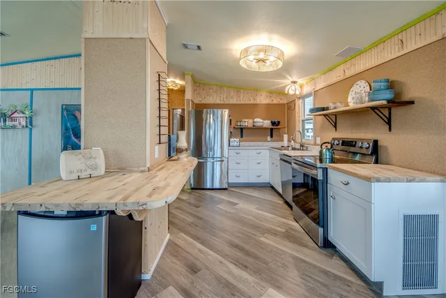 a kitchen with kitchen island a sink stove and refrigerator