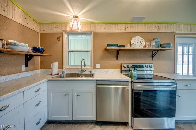 a kitchen with stainless steel appliances granite countertop a sink stove and wooden cabinets