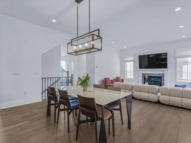 a view of a dining room with furniture a chandelier and wooden floor