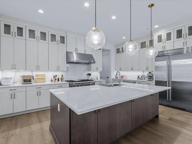 a kitchen with kitchen island a sink stainless steel appliances and cabinets