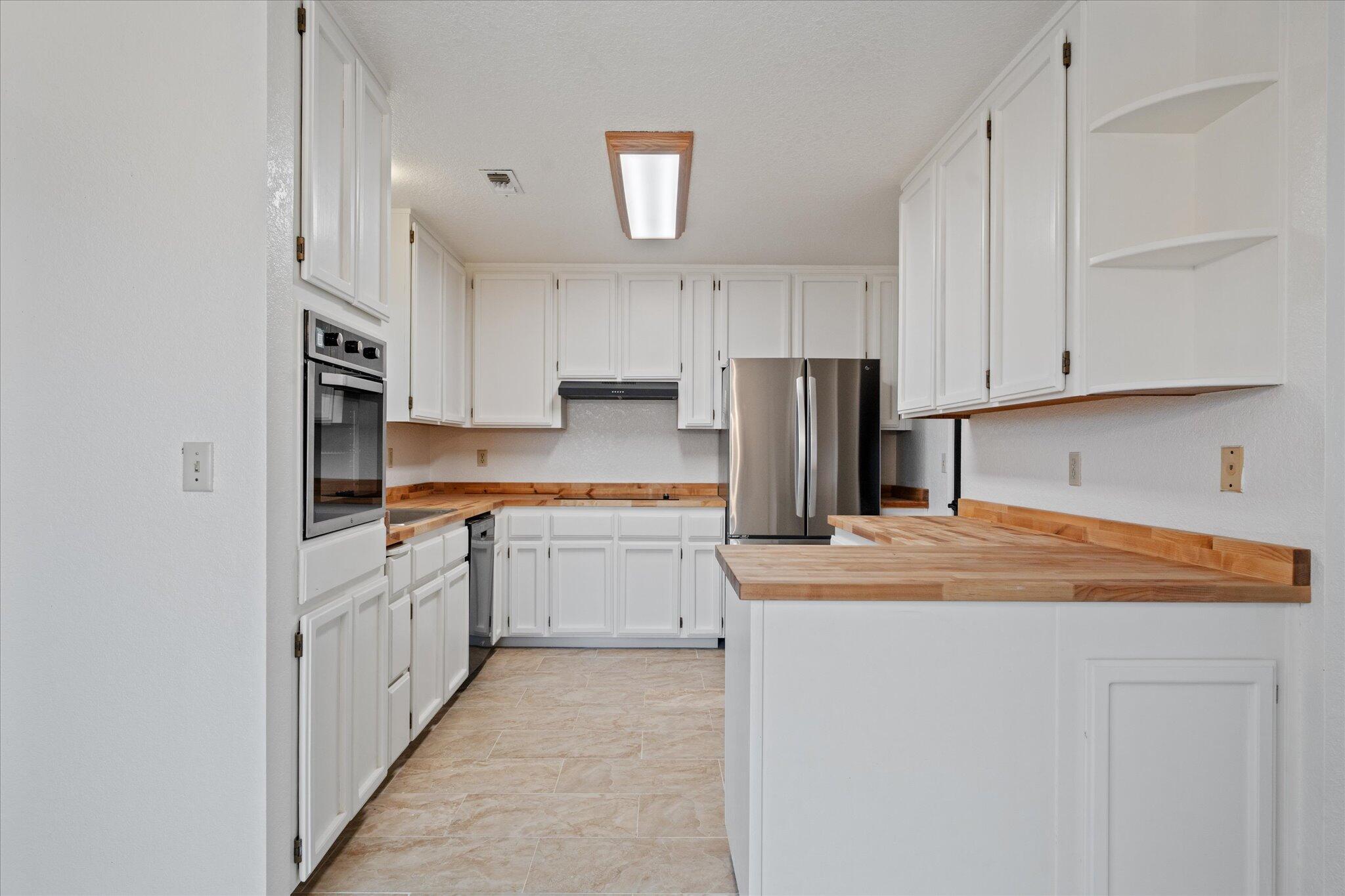 13770 Lisa Way Red Bluff, CA 96080 - Photo 15 of 43 a kitchen with stainless steel appliances granite countertop a refrigerator sink and white cabinets