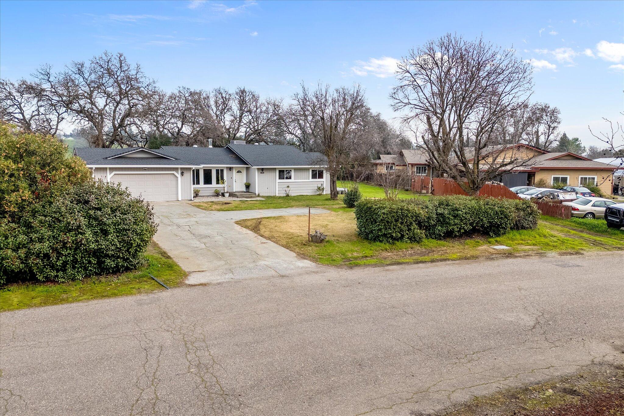 13770 Lisa Way Red Bluff, CA 96080 - Photo 3 of 43 a view of a house with a big yard and large trees