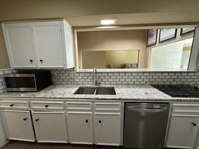 a kitchen with stainless steel appliances granite countertop a sink and cabinets
