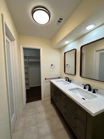 a bathroom with a double vanity sink and a mirror