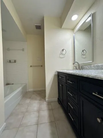 a bathroom with a bathtub sink vanity and a mirror