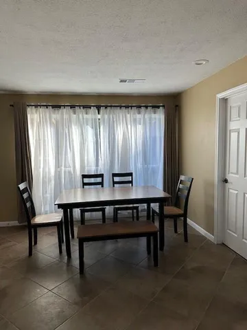 a view of a workspace with furniture and window