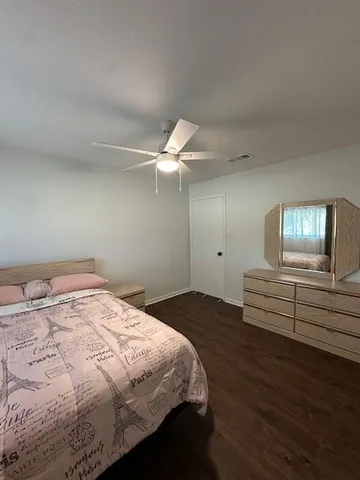 a bedroom with a bed and a chandelier fan