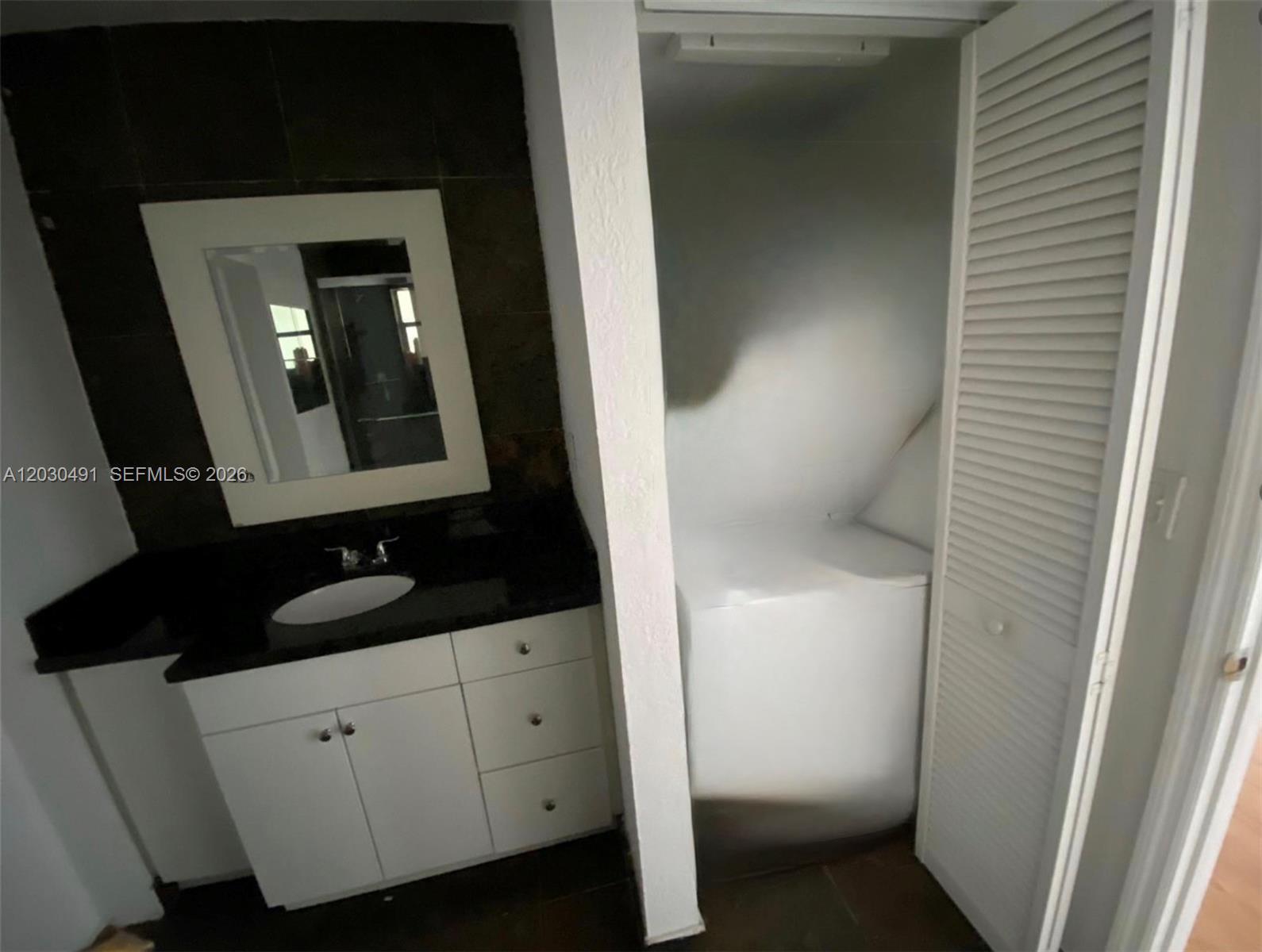 7410 Southwest 82nd Street, Unit K401 Miami, FL 33143 - Photo 5 of 5 a bathroom with a toilet sink and mirror