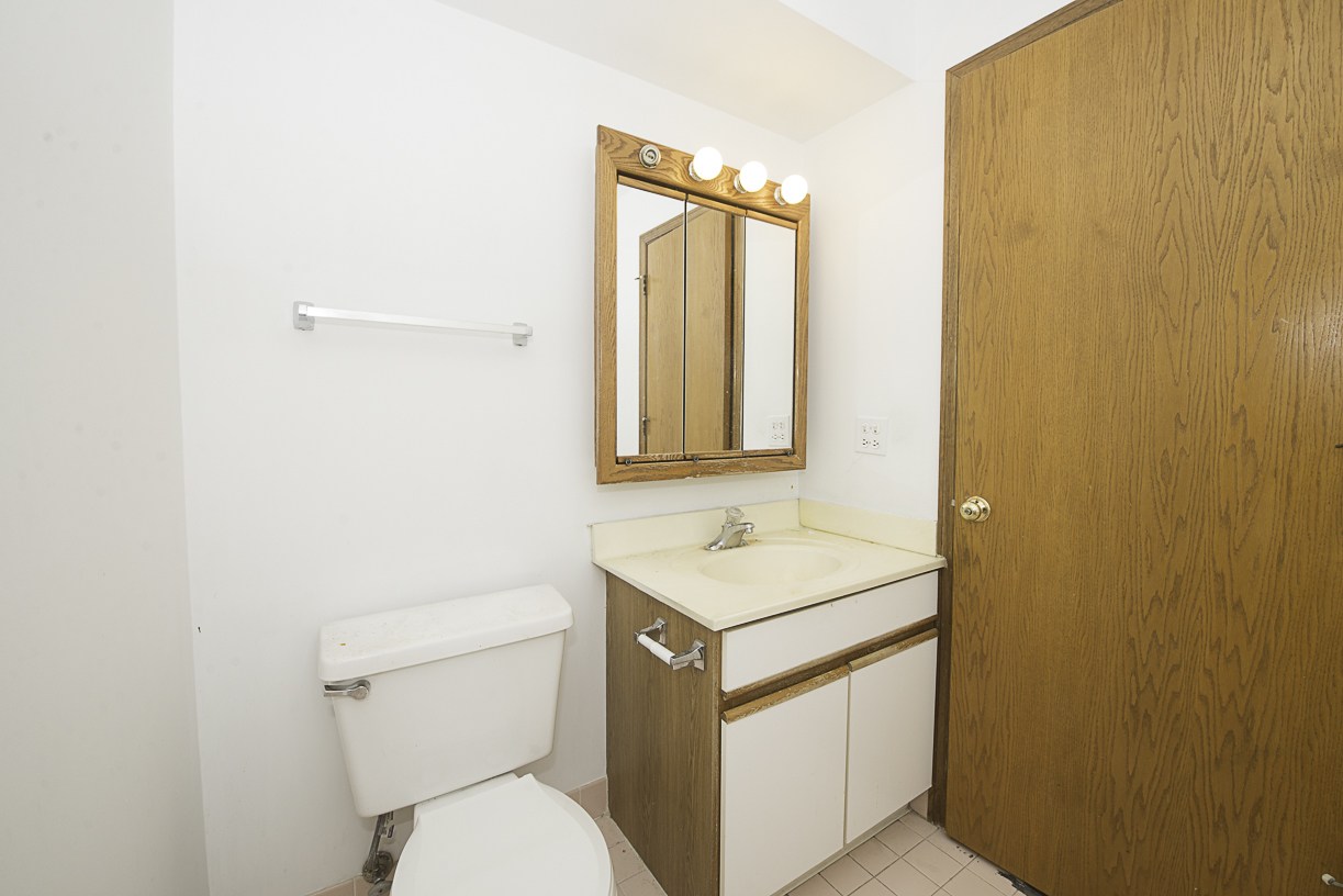 6540 West Irving Park Road, Unit 309 Chicago, IL 60634 - Photo 11 of 18 a bathroom with a toilet sink and mirror