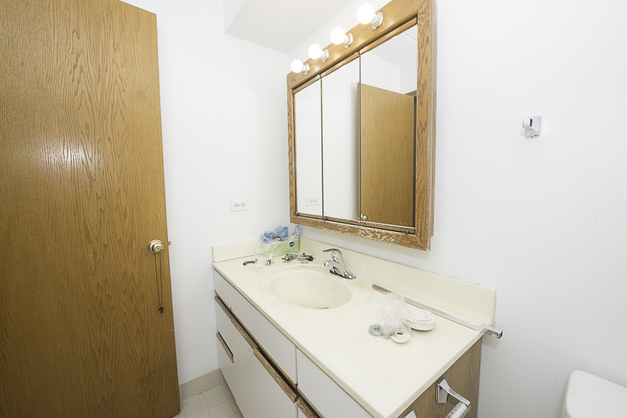 6540 West Irving Park Road, Unit 309 Chicago, IL 60634 - Photo 15 of 18 a bathroom with a sink and a mirror