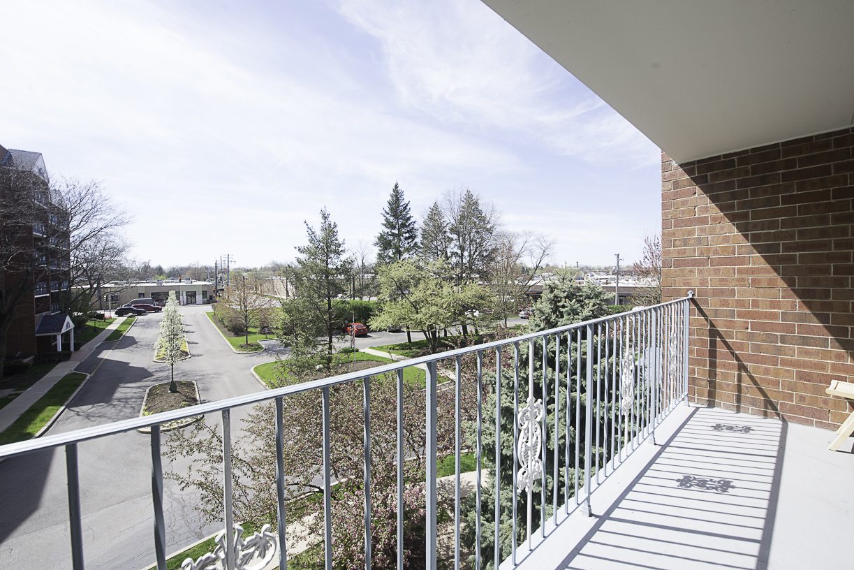 6540 West Irving Park Road, Unit 309 Chicago, IL 60634 - Photo 18 of 18 a view of a balcony with wooden floor and fence
