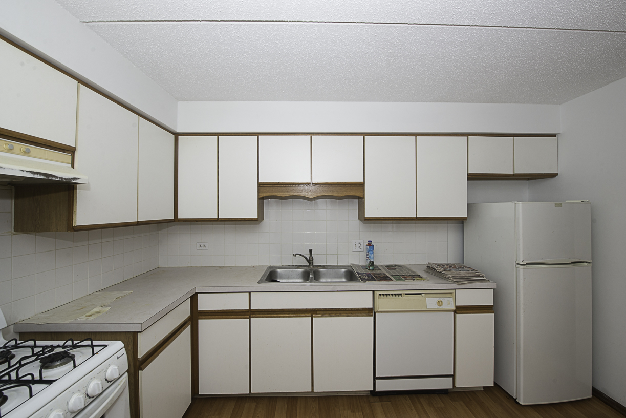 6540 West Irving Park Road, Unit 309 Chicago, IL 60634 - Photo 5 of 18 a kitchen with white cabinets and white appliances