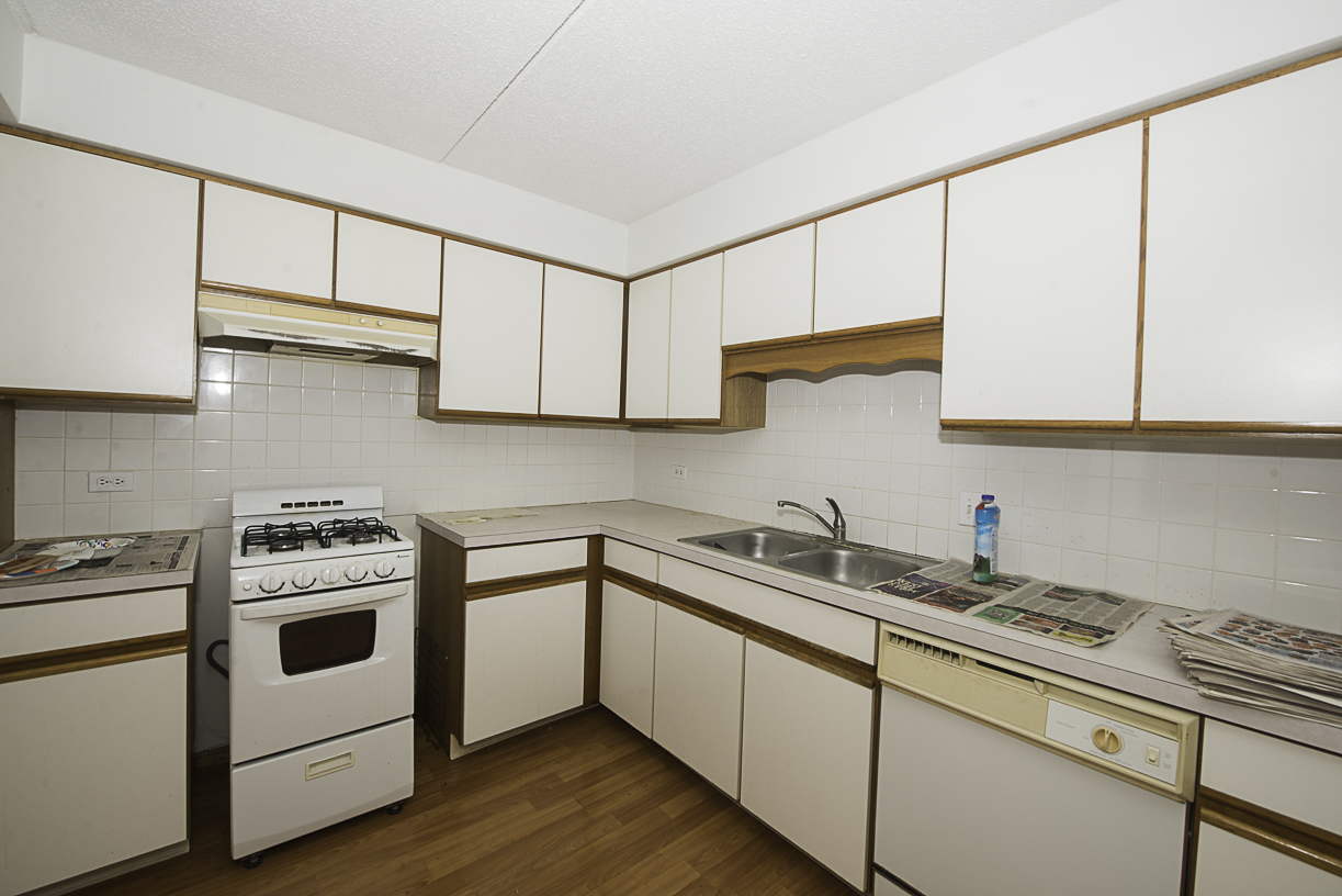 6540 West Irving Park Road, Unit 309 Chicago, IL 60634 - Photo 6 of 18 a kitchen with stainless steel appliances granite countertop white cabinets sink and stove