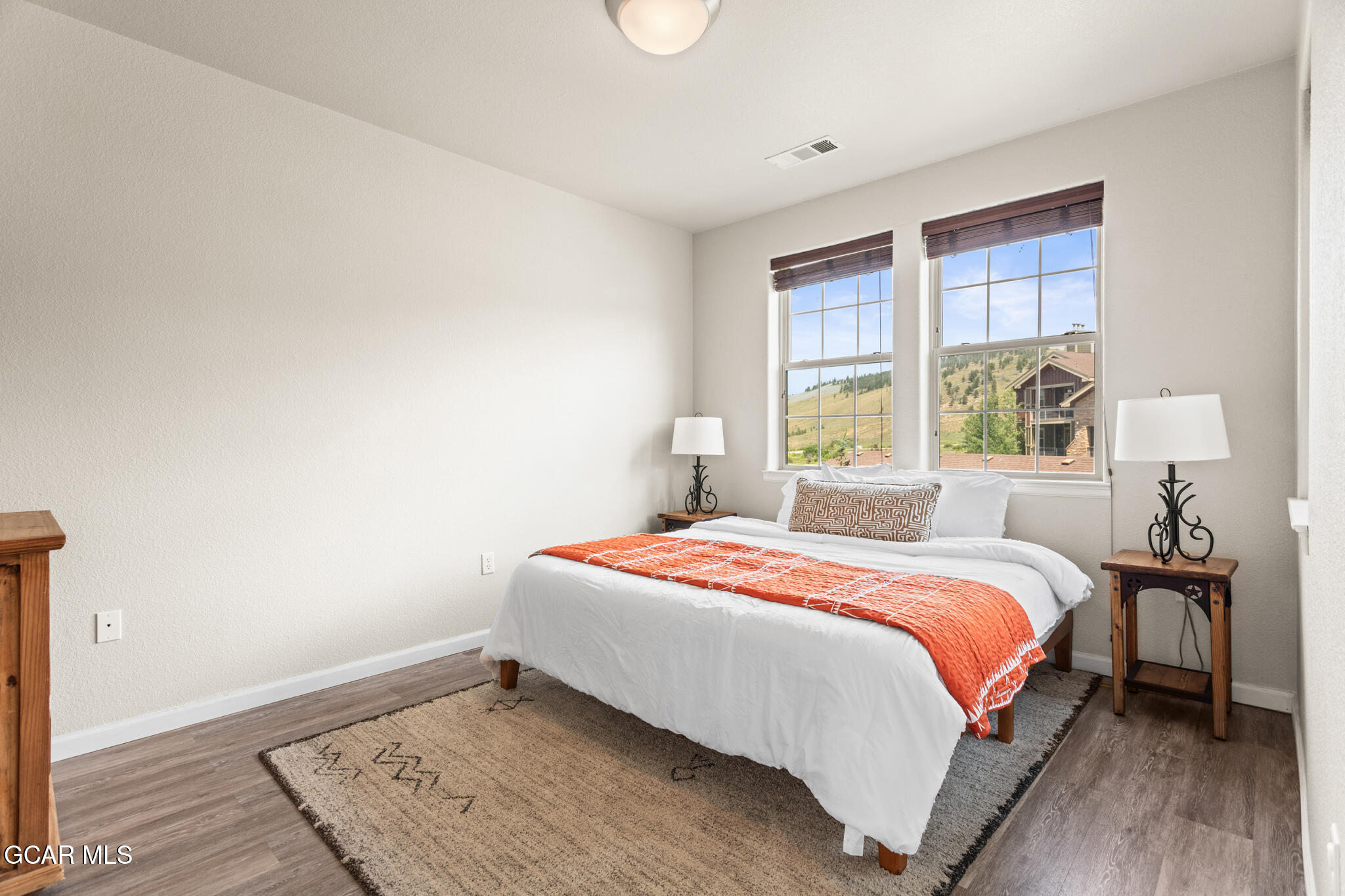 152 Village Road, Unit B206 Granby, CO 80446 - Photo 13 of 30 a bedroom with a bed and wooden floor