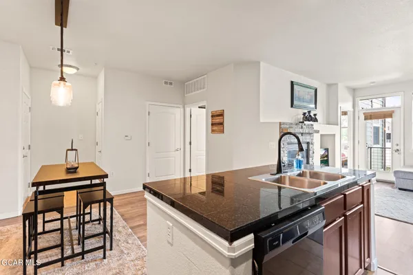 a kitchen with stainless steel appliances granite countertop a stove white cabinets a sink and a refrigerator