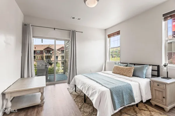 a bedroom with a large bed and a balcony view