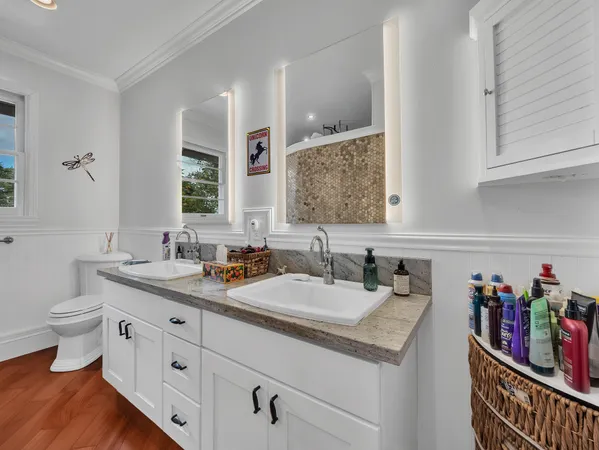 a bathroom with a granite countertop sink a toilet and a mirror