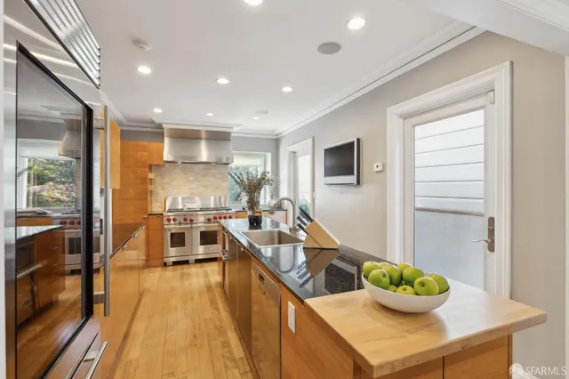 a kitchen with a potted plant on the counter and a wooden floor