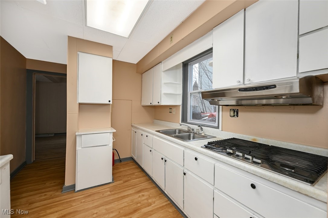 667 Elma Street Akron, OH 44310 - Photo 19 of 42 Kitchen with open shelves, white cabinetry, light countertops, stainless steel gas stovetop, and light wood-style flooring
