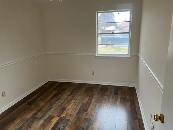 a view of a small space with wooden floor and a window
