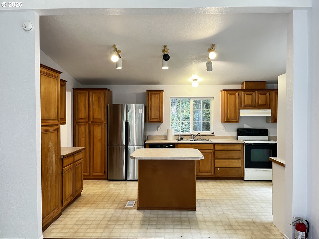 83411 Clear Lake Road Florence, OR 97439 - Photo 11 of 47 a large kitchen with kitchen island a sink stainless steel appliances and cabinets