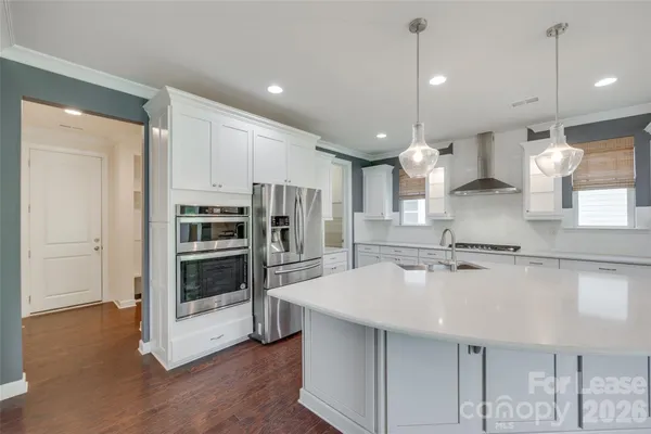 a kitchen with stainless steel appliances kitchen island granite countertop a sink refrigerator and cabinets