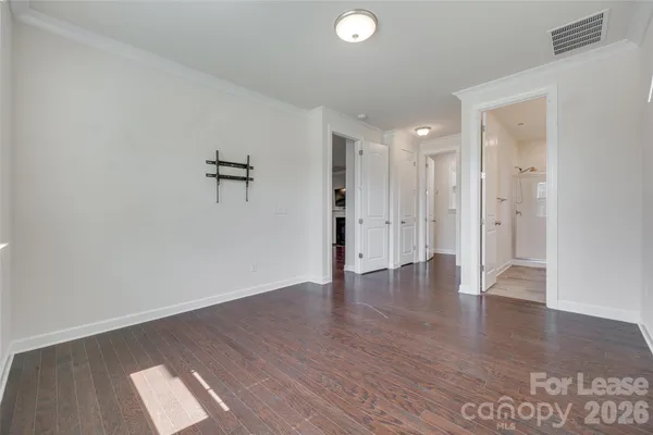 a view of an empty room with wooden floor