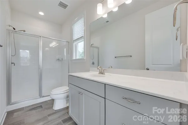 a bathroom with a double vanity sink toilet and shower