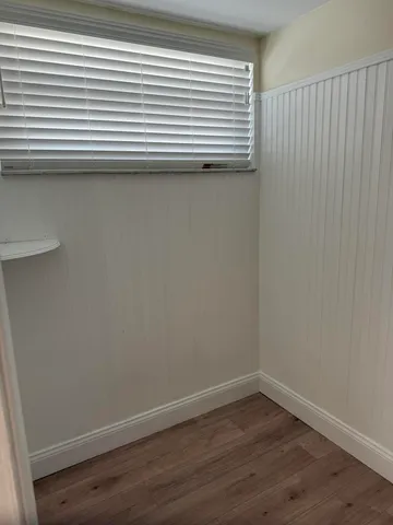 a view of a small space with wooden floor and a window