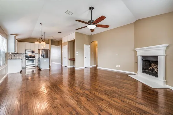 a view of a kitchen with wooden floor and a fireplace