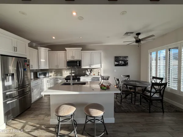 a kitchen with granite countertop a table chairs microwave and cabinets
