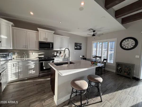 a kitchen with a dining table chairs and white cabinets