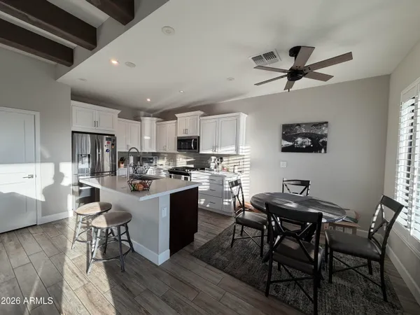 a kitchen with a table chairs refrigerator and microwave