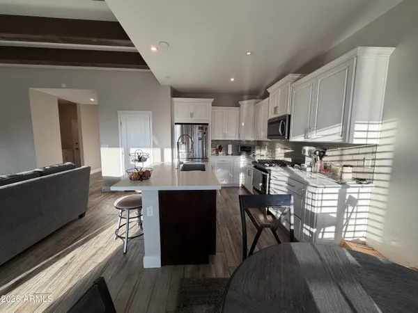 a kitchen with stainless steel appliances kitchen island granite countertop a stove a sink a microwave and cabinets