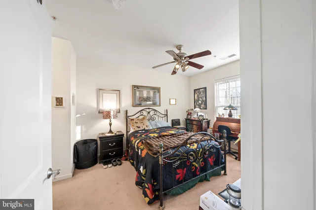 a bed room with a bed mirror and a chair