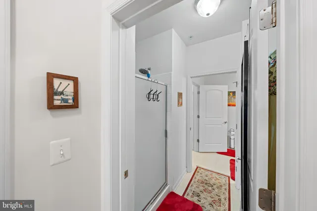 a view of a hallway with closet and a bathroom